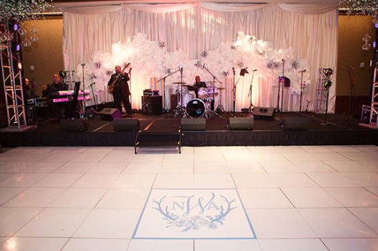 Wedding band performance on stage with floral backdrop