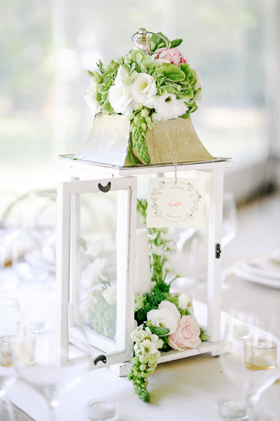 White lantern centerpiece with pink roses and green