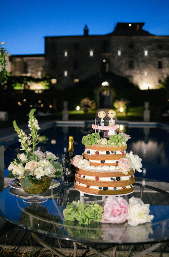 Rustic wedding cake with flowers and champagne outdoors