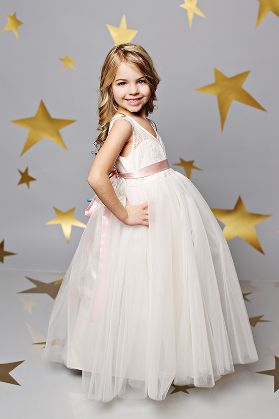 Adorable girl in a pretty white tulle dress