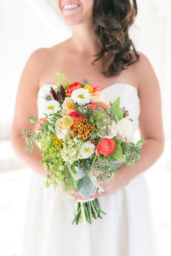 Bride holds vibrant colorful wedding bouquet flowers