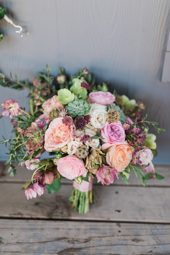 Wedding bouquet of pink and peach roses on wood table