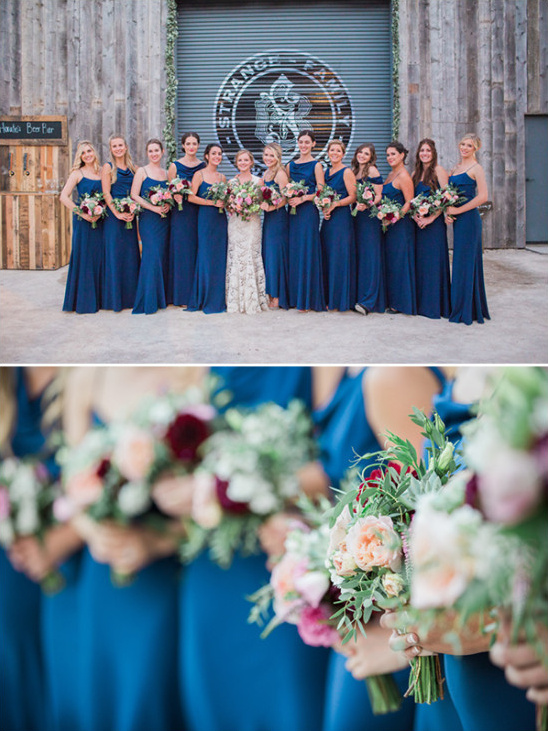 Bride with bridesmaids in blue dresses holding flowers