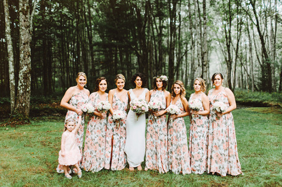 Bride and bridesmaids in floral gowns in a forest