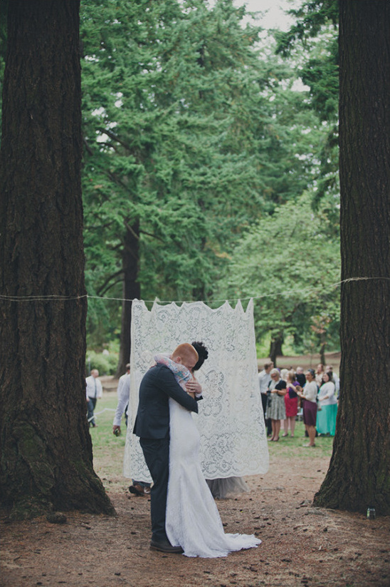 Bride and groom embrace after outdoor wedding ceremony