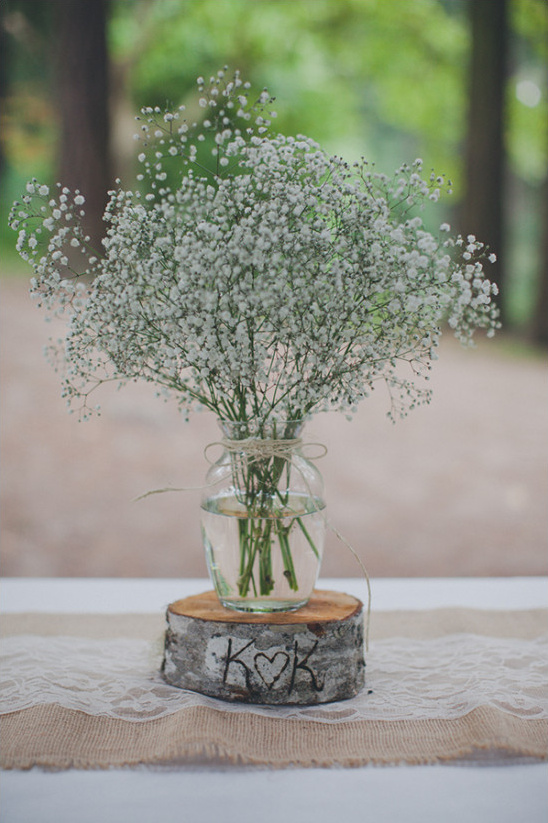 Baby's breath in glass vase on rustic wood, KK initials