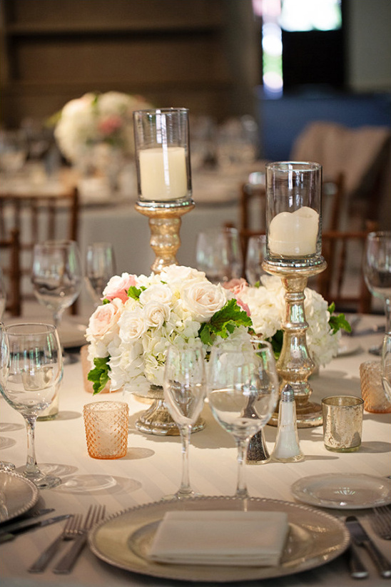 Elegant wedding centerpiece: candles, flowers, and glassware