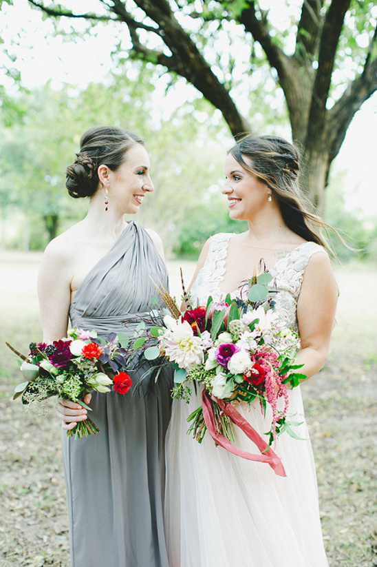 Bride and bridesmaid with bouquets at outdoor wedding