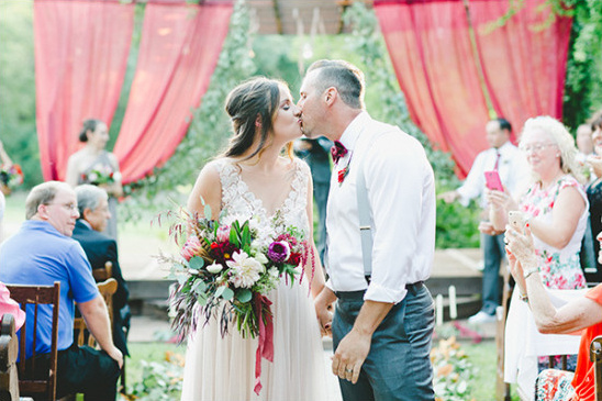 Newlyweds share first kiss at outdoor garden wedding
