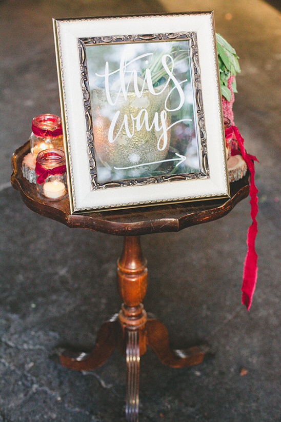 Rustic wedding decor with This Way sign on table