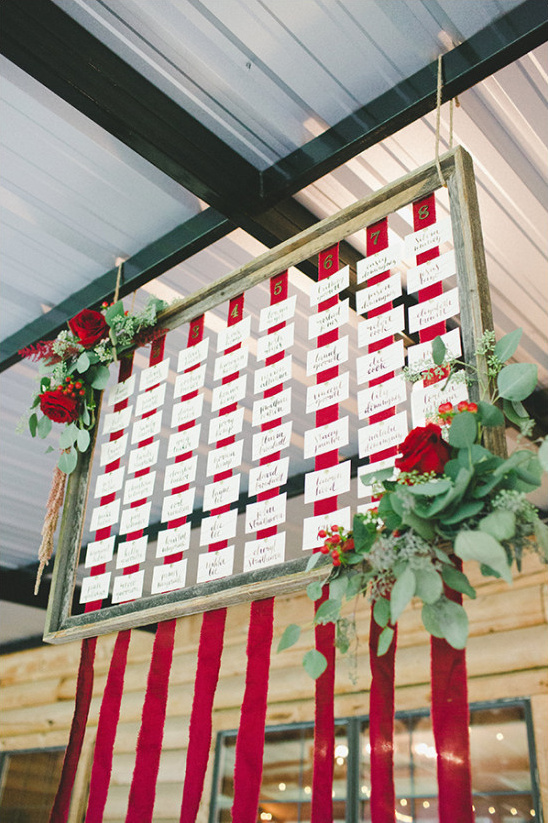Rustic wedding seating chart with floral accents and red ribbons