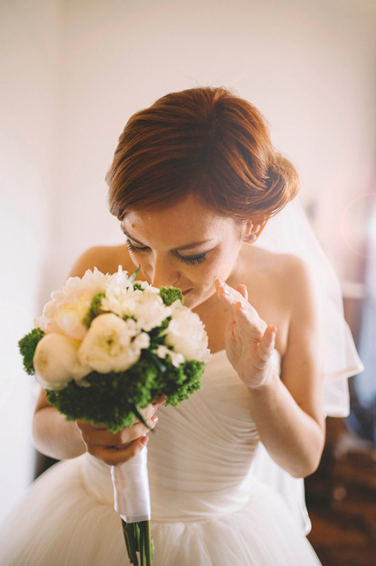 Bride smelling beautiful white wedding bouquet