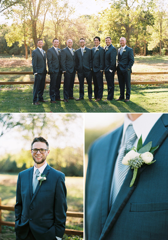 Smiling groomsmen in blue suits at outdoor wedding
