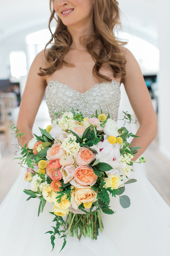 Bride holding a beautiful peach and yellow wedding bouquet