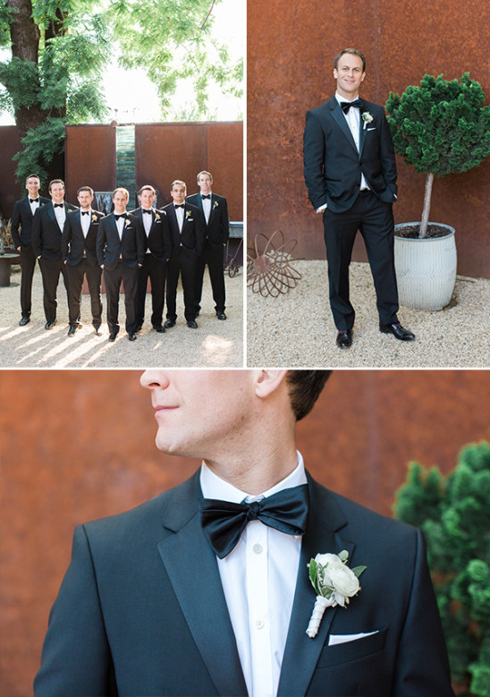 Groomsmen in black tuxedos posing for wedding photo