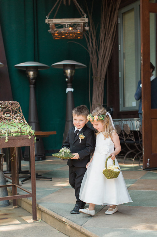 Adorable flower girl and ring bearer walking down aisle