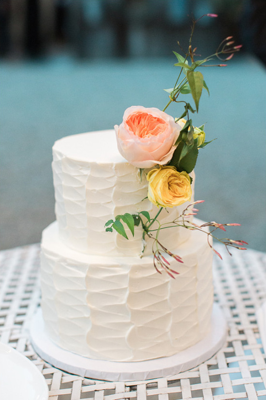 Two-tiered wedding cake with peach and yellow roses