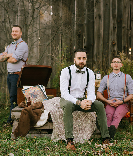 Three groomsmen with suspenders and bowties outdoors