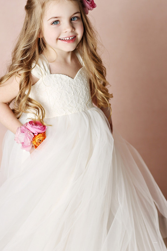 Smiling girl in flower girl dress with flowers