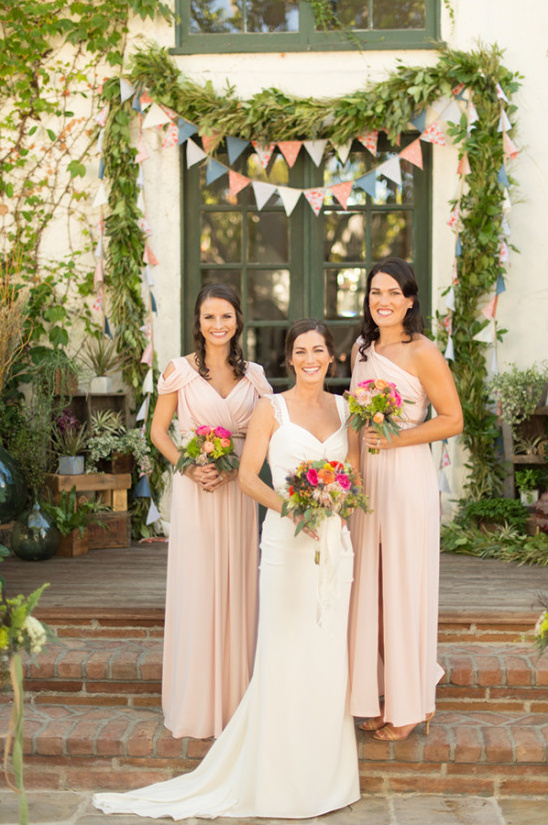 Bride and two bridesmaids in pink dresses and bouquets