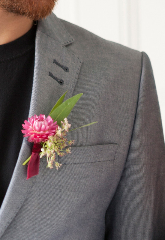 Groom in gray suit with a pink floral boutonniere
