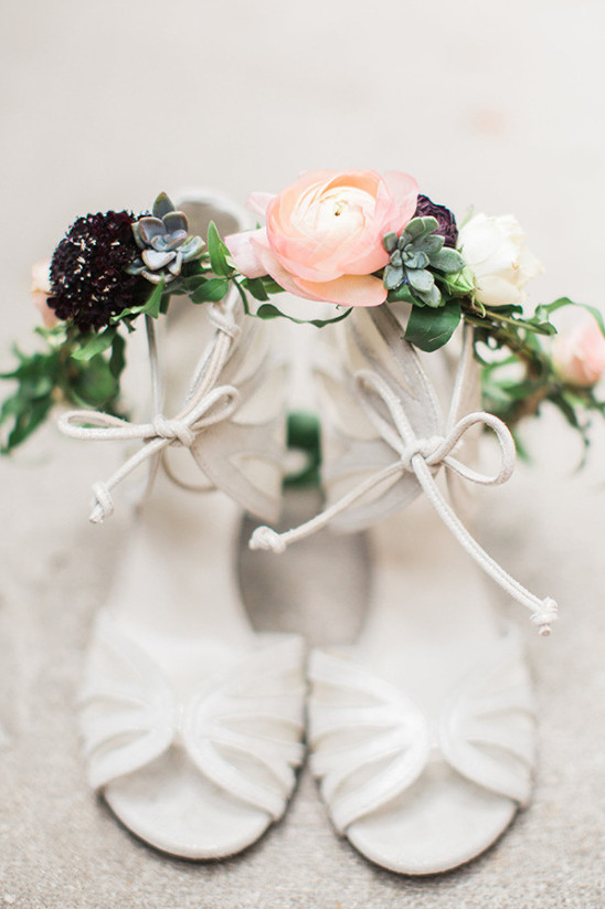 White wedding shoes with floral arrangement on top