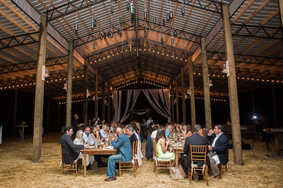 Barn wedding reception with string lights and guests