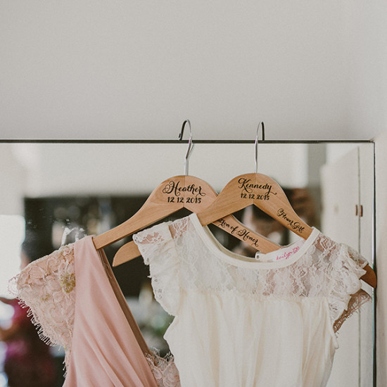 Wedding dresses hanging on personalized wooden hangers