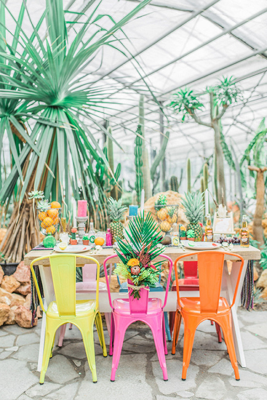 Tropical themed table setting with colorful chairs and decor