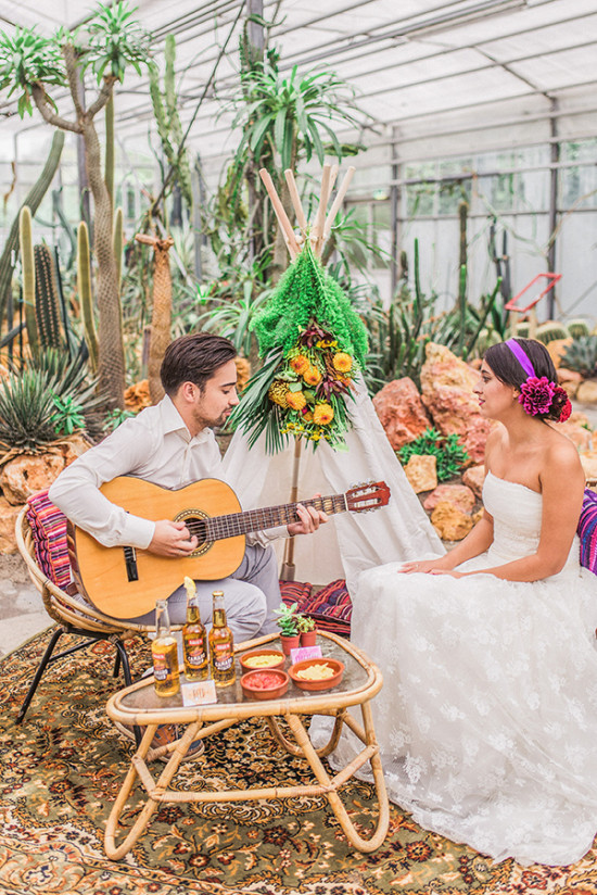 Bride and groom enjoy music at a bohemian wedding surrounded by cacti