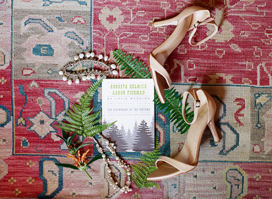 Wedding details with heels and invitation on a patterned rug