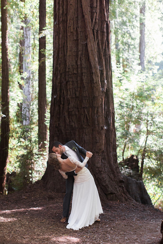 Couple kissing in a redwood forest at their wedding ceremony