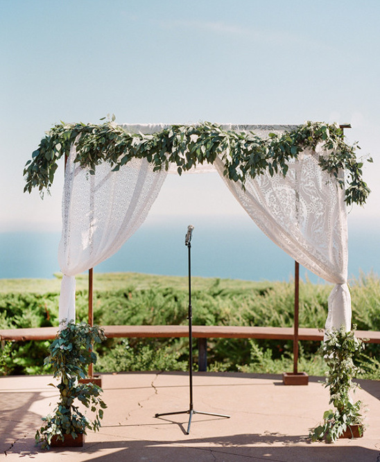 Seaside wedding arch with green garland