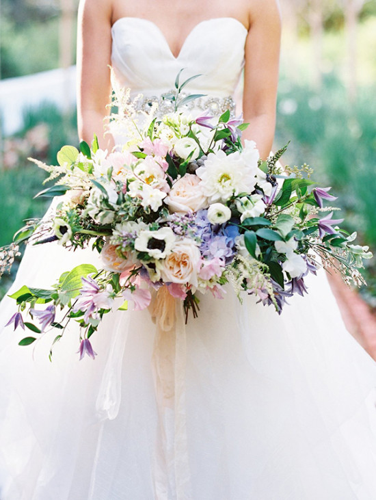 Bride in white gown holding colorful wedding bouquet