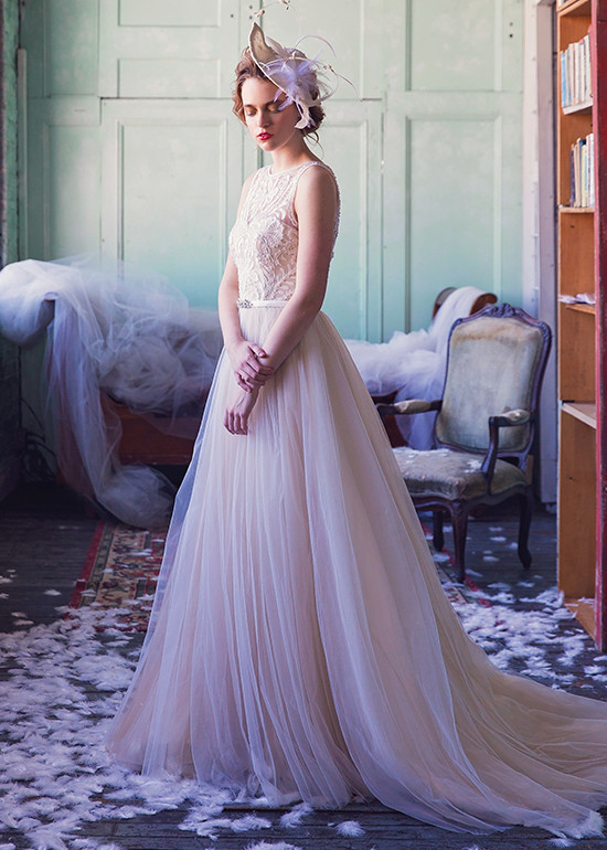 Bride models vintage tulle gown with feather fascinator