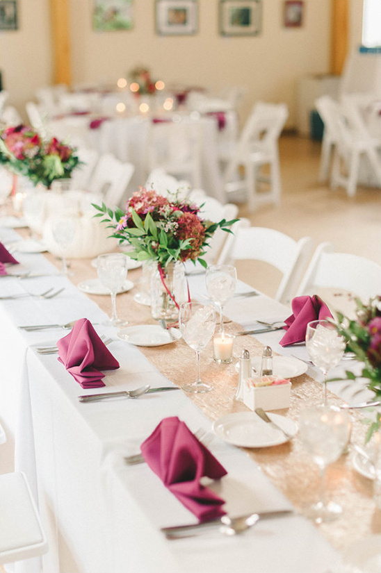 Elegant wedding table setting with flowers and burgundy napkins