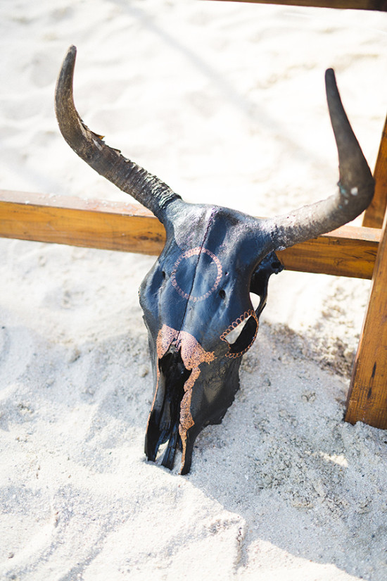 Black painted cow skull artfully placed on white sand