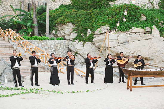 Mariachi band plays music on a beach setting for a special event
