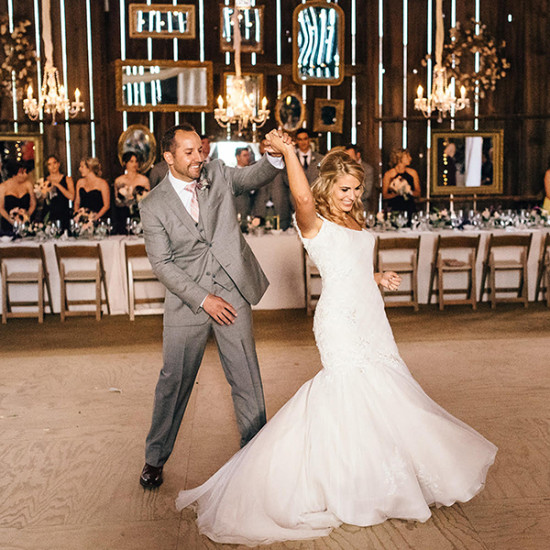 Happy bride and groom dancing at their rustic barn wedding