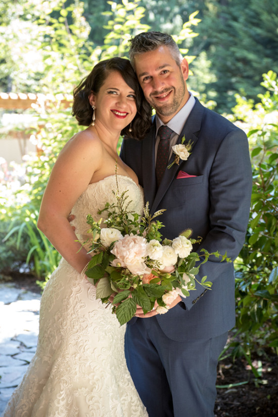 Happy couple smiling on their wedding day with bouquet