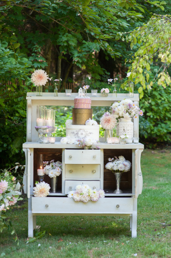 Wedding decor with cake and flowers on a vintage cabinet in nature