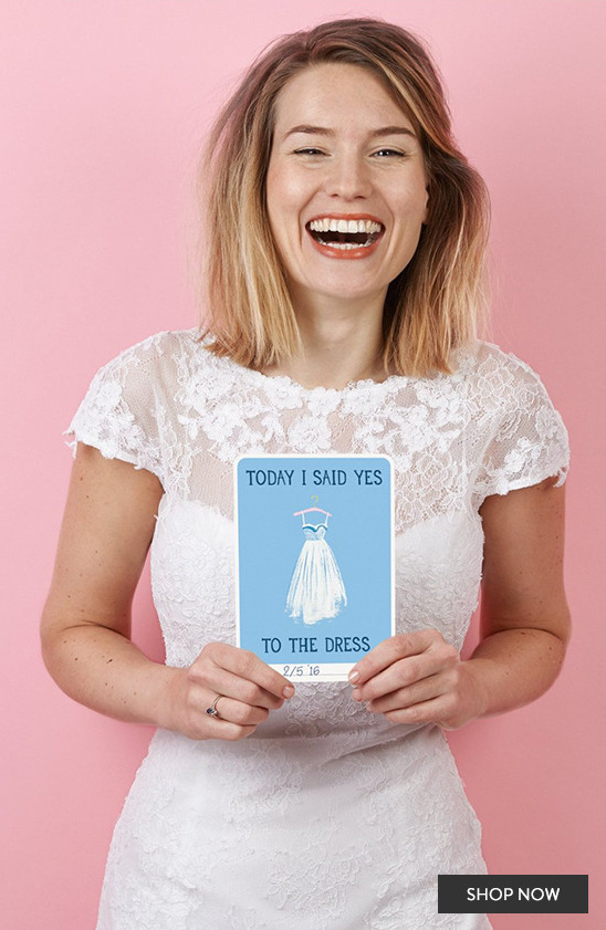 Bride happily showing a card saying Yes to the Dress on her wedding