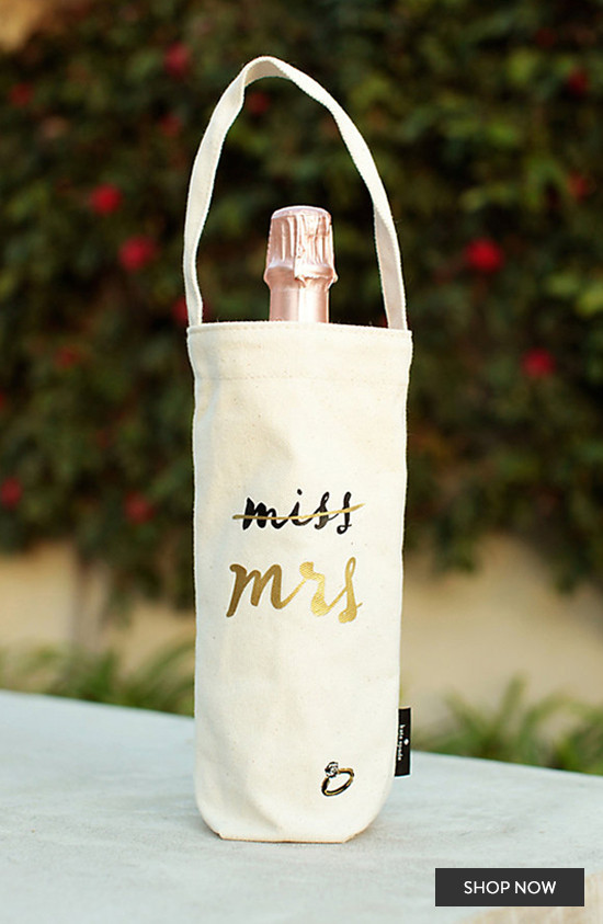 Champagne bottle bag with Miss to Mrs text and ring on white cloth
