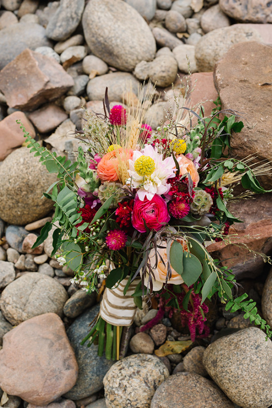 Colorful wedding bouquet resting on natural river stones