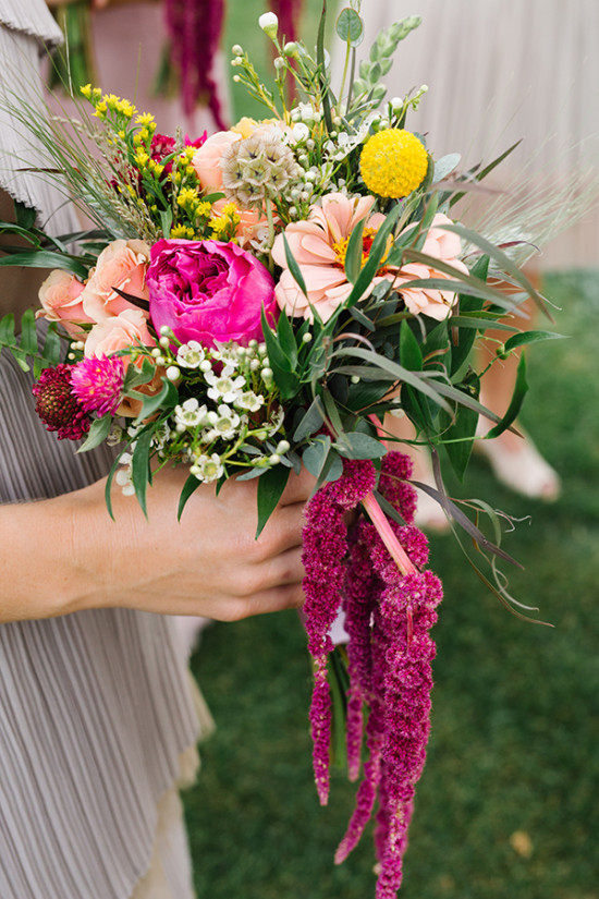 Vibrant floral bouquet with rich pink and yellow flowers held tenderly