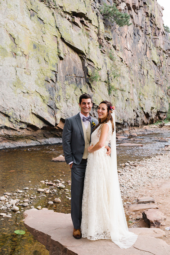 Happy couple on their wedding day, posing by a river