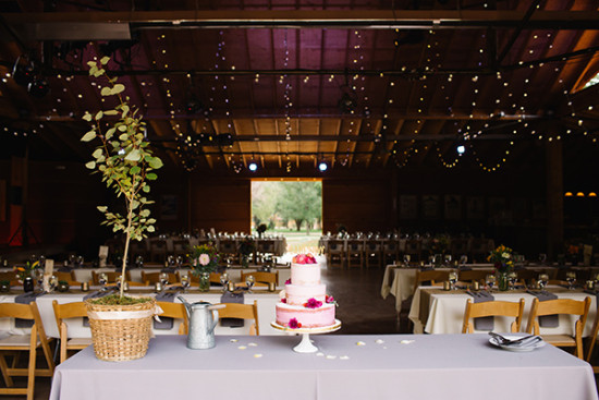 Wedding reception with cake and fairy lights in a barn