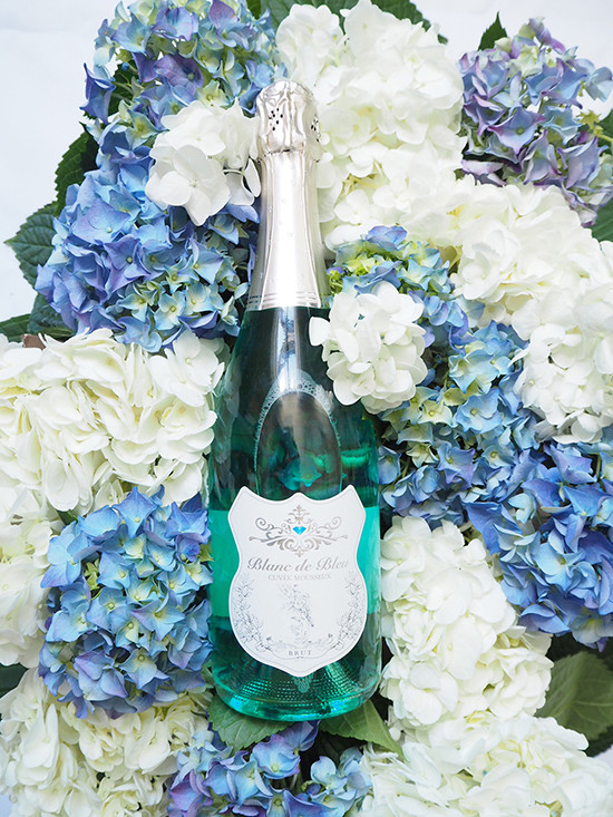 Blanc de Bleu champagne bottle with hydrangea flowers bouquet
