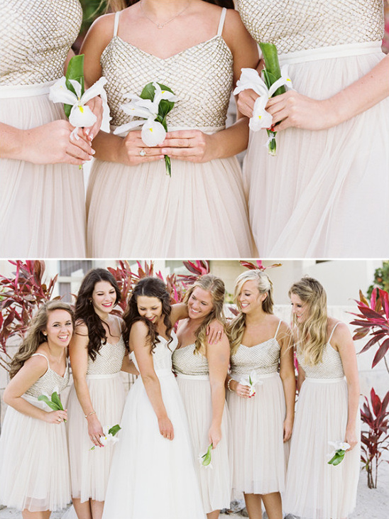 Bridesmaids in sparkling dresses hold flowers, ready for wedding