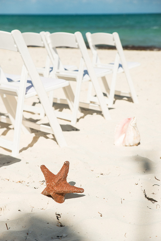 Beach wedding setup with chairs, starfish, and seashell